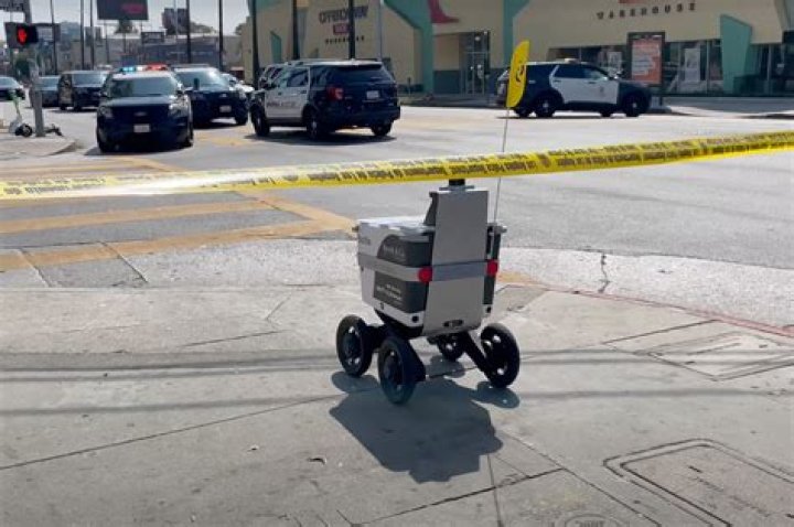 Food delivery robot casually rolls through LA crime scene
